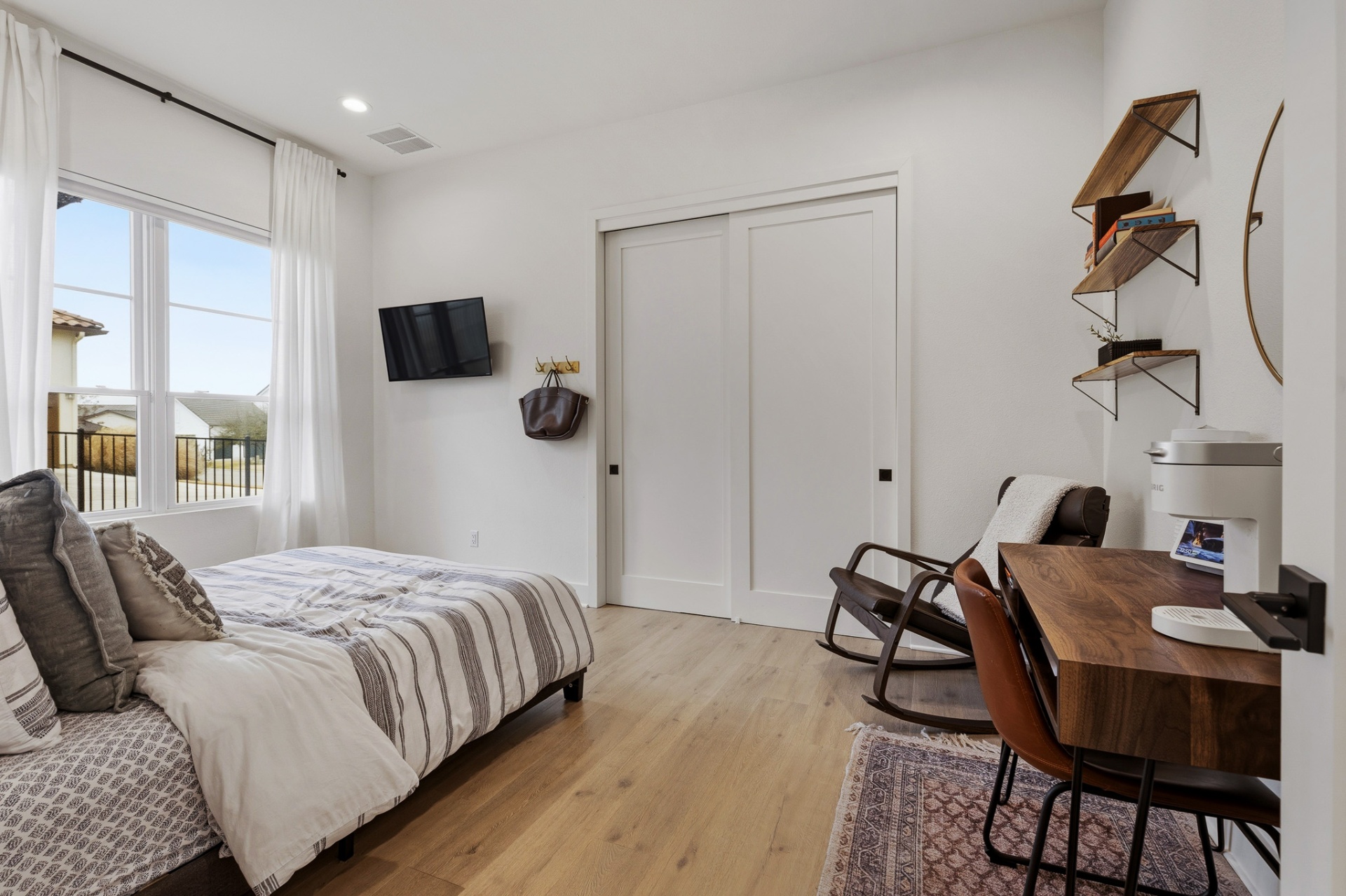 Bedroom 2 with TV, striped bedding, rocking chair and sliding-door closet