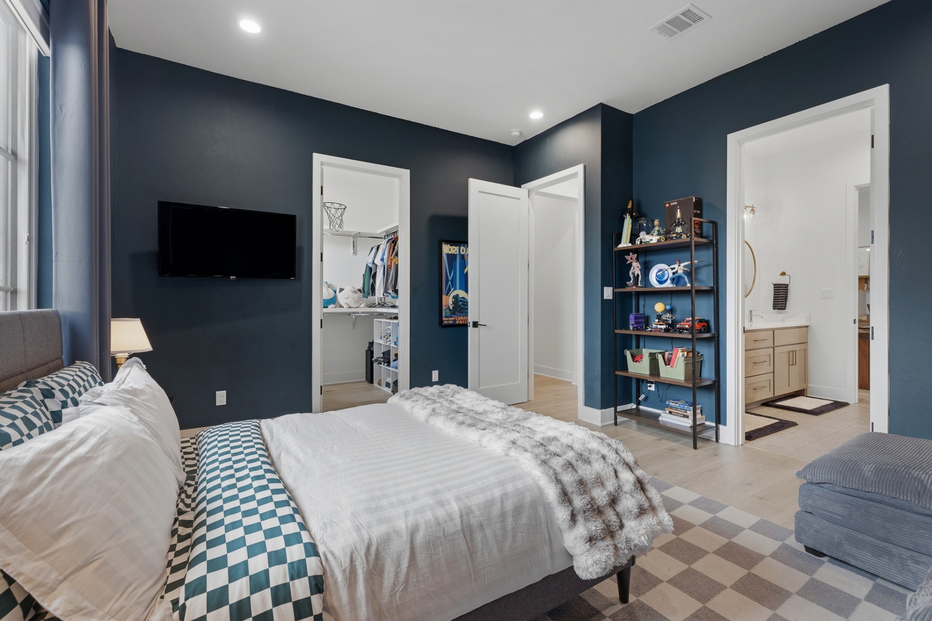 Bedroom 3 — navy walls, checkered bedding, walk-in closet and en-suite bath doorways