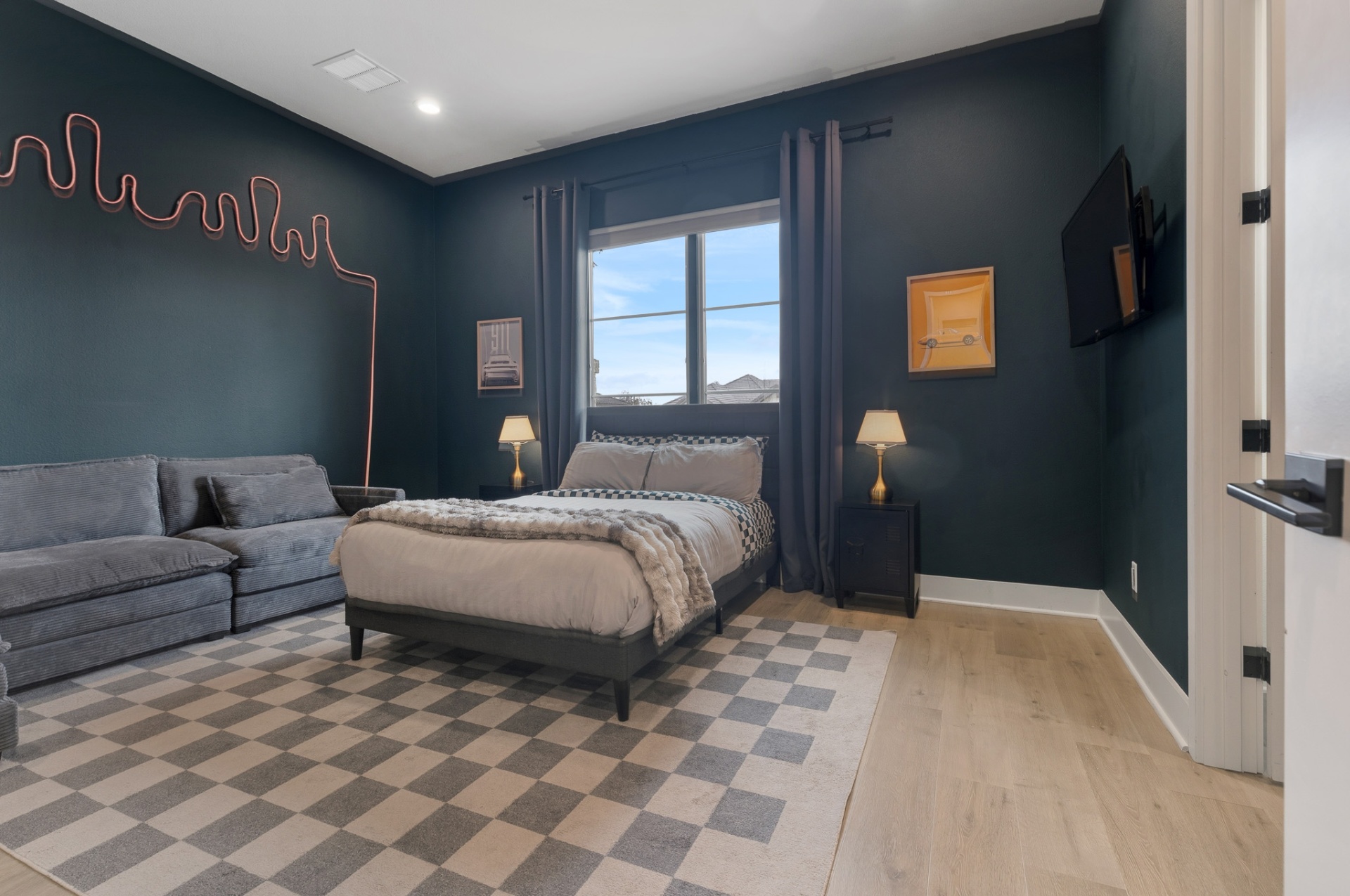 Bedroom 3 — car art, neon sign, sectional sofa, TV and navy walls