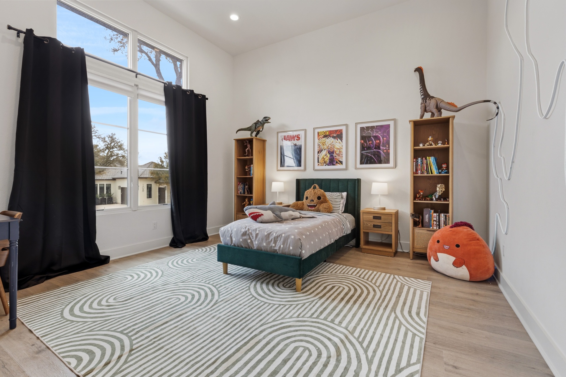 Bedroom 5 — green velvet bed, dinosaur bookends, Jaws & Dragon Ball art, swirl area rug